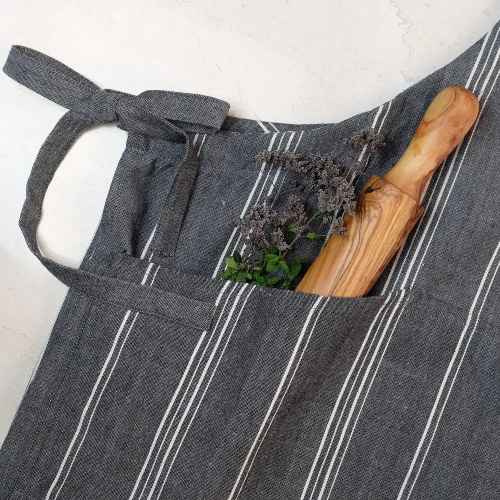 Charcoal gray handmade cooking apron with white stripes, spoon and herbs