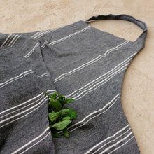 Charcoal gray full-length cooking apron with white diagonal stripes made of textured fabric perfect for summer bbqs and cooking attire