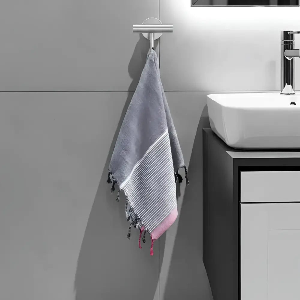 Gray and pink striped turkish cotton towel with tassels hanging from silver hook ruby striped turkish style