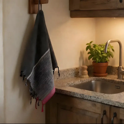 Dark gray and pink striped turkish towel with fringed edges made of soft turkish cotton in ruby striped turkish style
