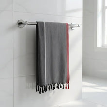Charcoal white and ruby striped turkish hand towel with gray and red stripes and black tassels hanging on chrome rack