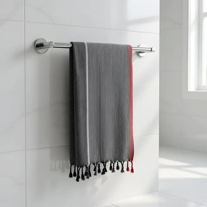Charcoal white and ruby striped turkish hand towel with gray and red stripes and black tassels hanging on chrome rack