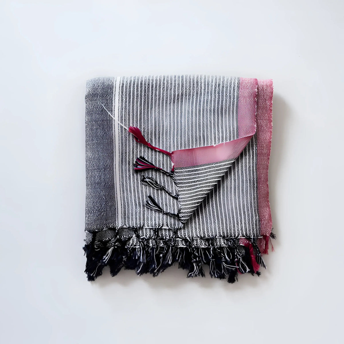 Folded Charcoal and Ruby Striped Turkish Bath Towel made from Turkish cotton with tassels