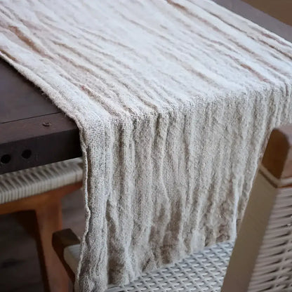 Table runner in textured linen hanging off of table.