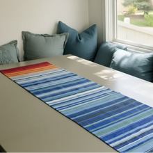 A handmade climate warming ethiopian handwoven table runner in blue, red, orange, and green 