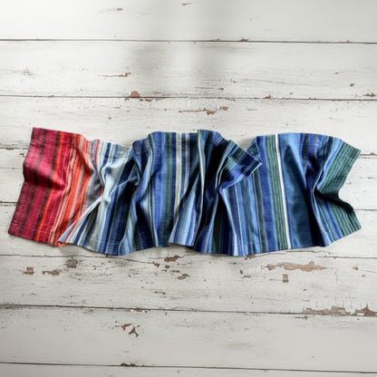 A handmade climate warming table runner with bold vertical stripes in red orange blue and green