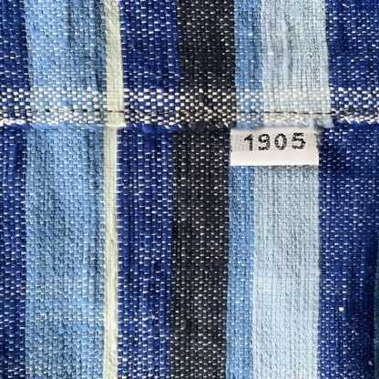 Vintage-style handmade ethiopian table runner with woven fabric in blue green and black stripes highlighting climate warming
