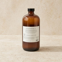 A sleek amber glass bottle with black cap labeled coconut bath soak by baudelaire replenishing 40oz for skin texture