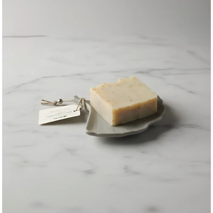 Off-white soap bar with speckles on concrete gingko leaf dish