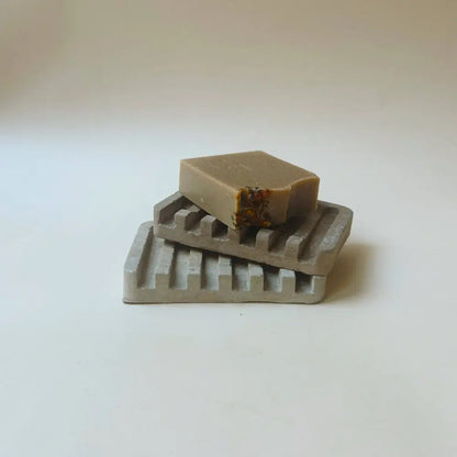Hand poured concrete and botanical powders soap dishes in brown or gray.