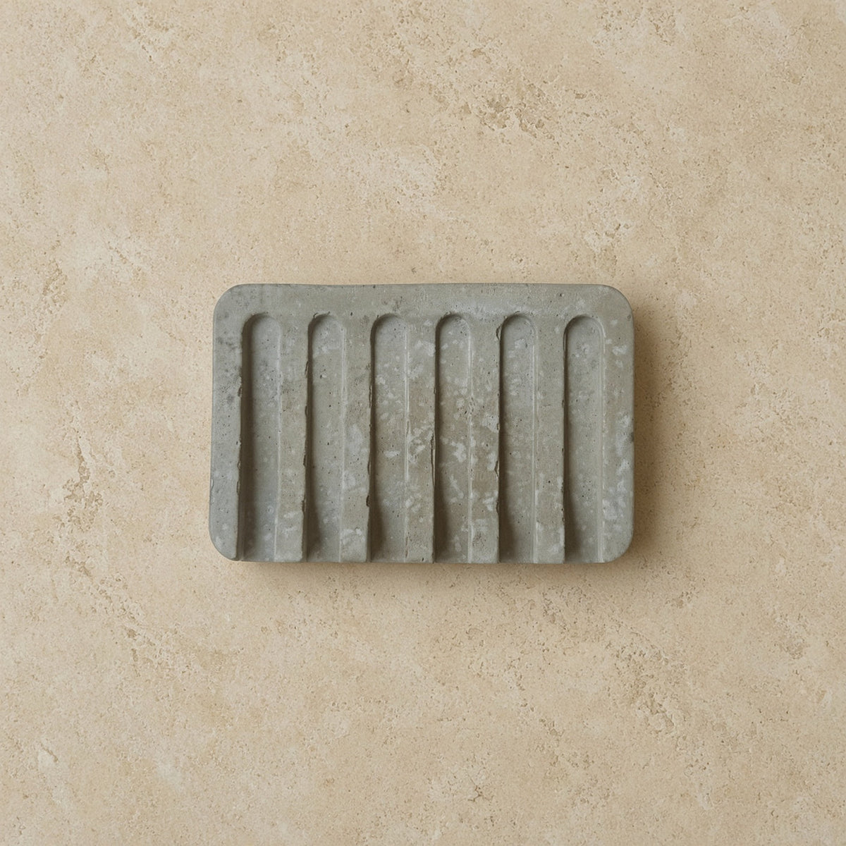 Gray hand poured concrete soap tray with vertical ridges perfect as a durable concrete tray for soap storage