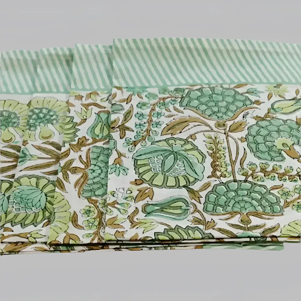 A cotton napkin with traditional Indian block print designs in green and brown.