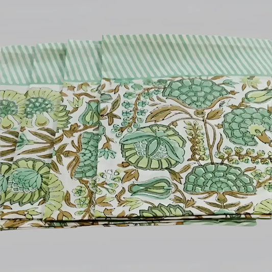 A cotton napkin with traditional Indian block print designs in green and brown.