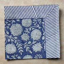 Cotton block print napkin with traditional floral pattern and striped border in blue and white