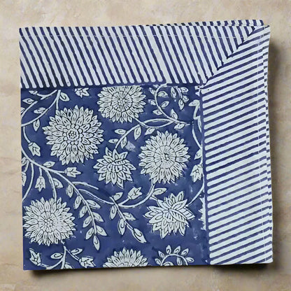 Cotton block print napkin with traditional floral pattern and striped border in blue and white