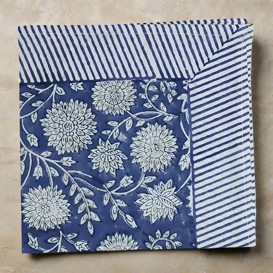 Cotton block print napkin with traditional floral pattern and striped border in blue and white
