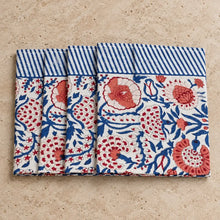 Set of four white cotton napkins with vibrant red and blue floral patterns and striped border in traditional indian block print style