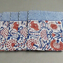 Cotton block print napkins with white fabric, blue stripes, and coral floral patterns