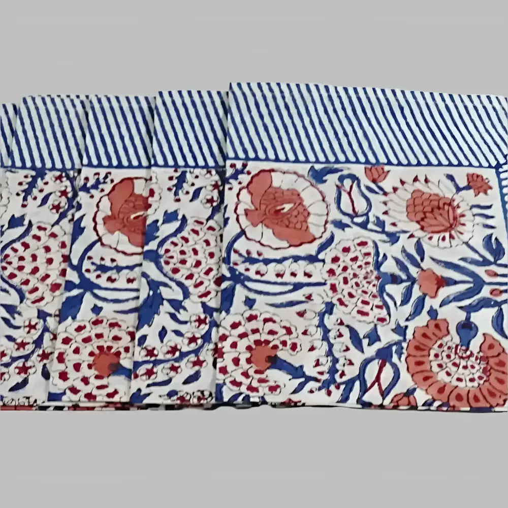 A cotton napkin with traditional Indian block print patterns in navy, red, and salmon.