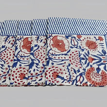 A cotton napkin with traditional Indian block print patterns in navy, red, and salmon.