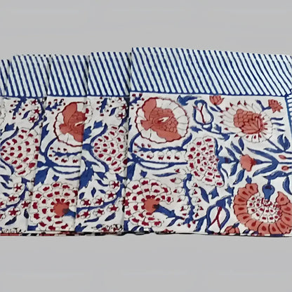 A cotton napkin with traditional Indian block print patterns in navy, red, and salmon.