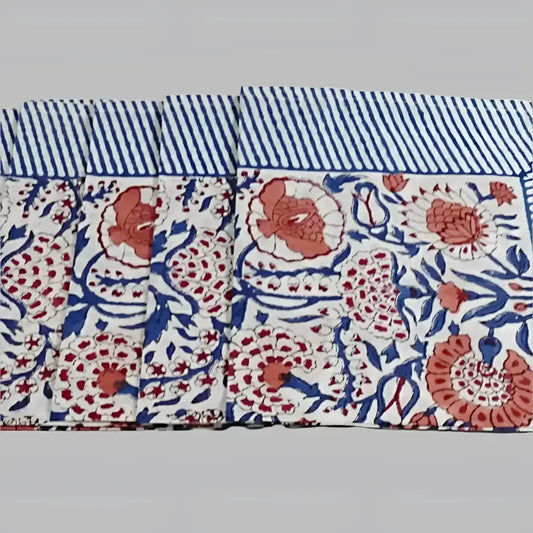 A cotton napkin with traditional Indian block print patterns in navy, red, and salmon.