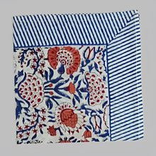 A cotton napkin with traditional Indian block print patterns in navy, red, and salmon.