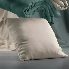 an off white pillow on the floor
