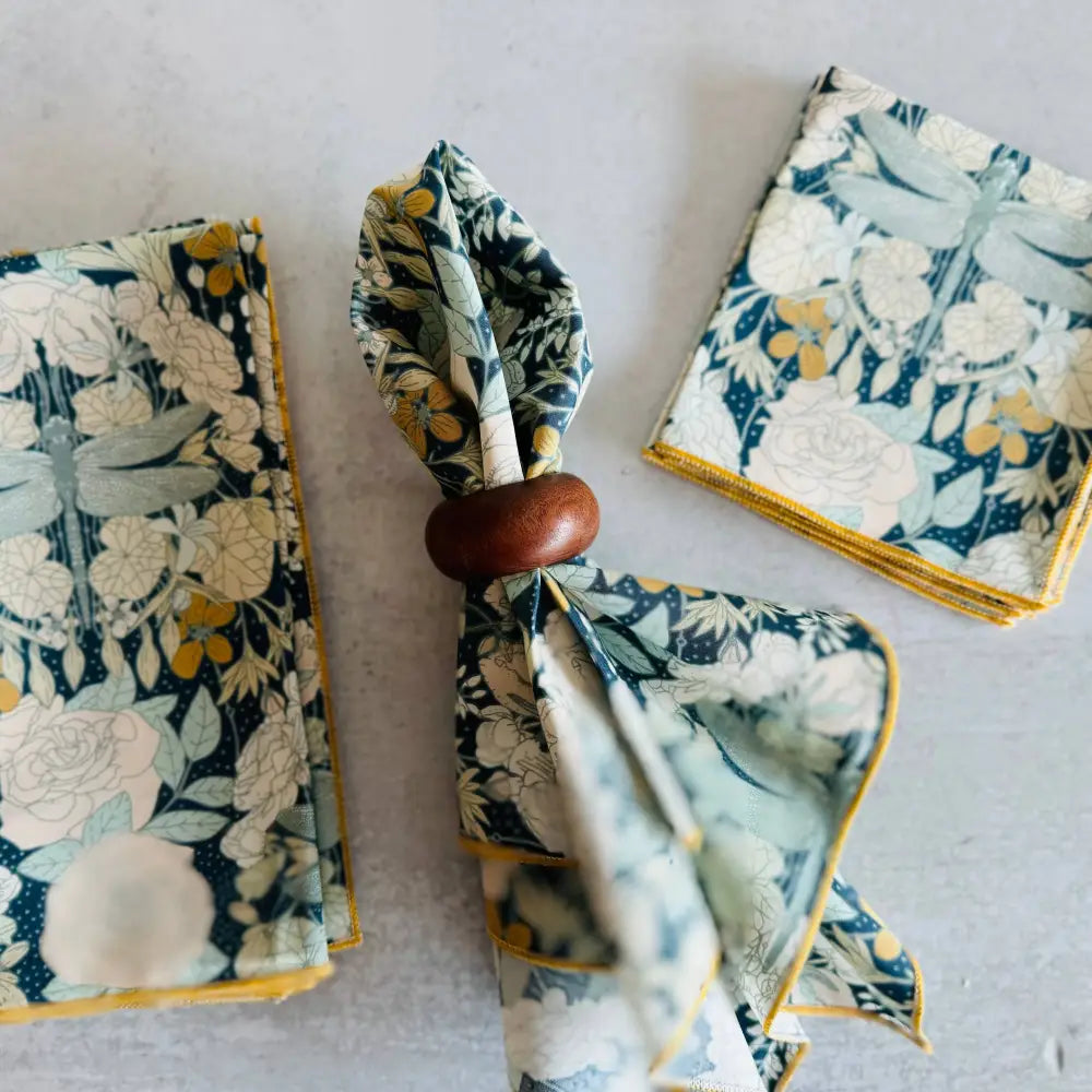 Set of floral-patterned napkins with a wooden knot on a light gray background