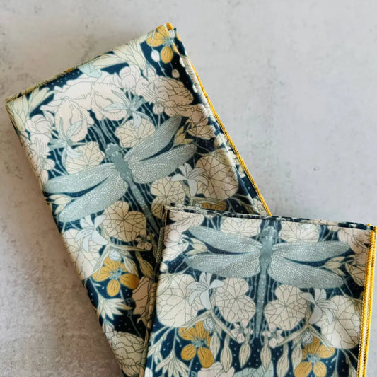 Two fabric items with dragonfly pattern on a light gray background