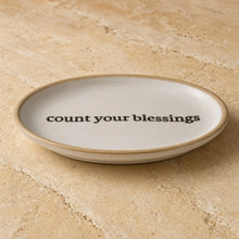 Cream-colored ceramic trinket dish with rustic rim and uplifting message count your blessings for daily reminders