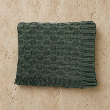 A dark green curvy green throw cable knit with a textured interwoven pattern made of soft washed cotton throw