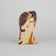 A wooden angel wall hanging with layered carved wings and robes in natural tones in a keepsake gift box by carver dan
