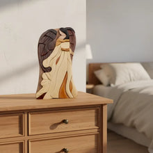 A wooden angel figurine with layered wings in cream brown and amber tones from carver dan’s keepsake gift box
