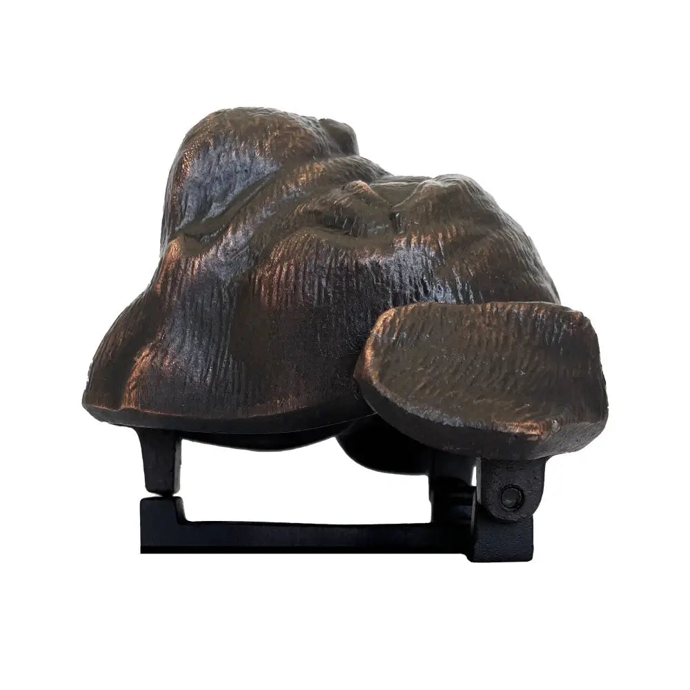 Bronze-colored sculpture of a dog on a white background