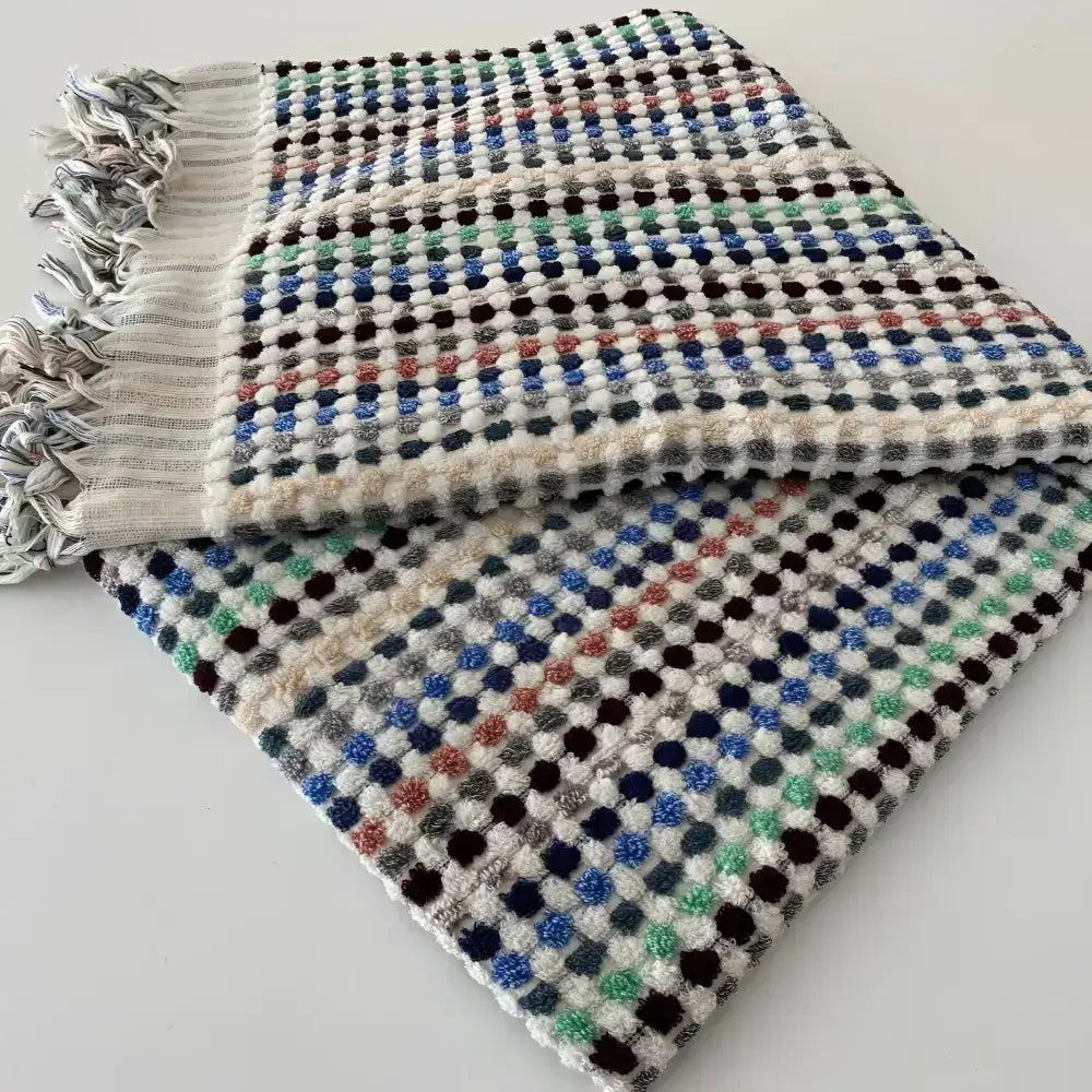 Handwoven Turkish terrycloth towel with dots in multiple colors and fringe.
