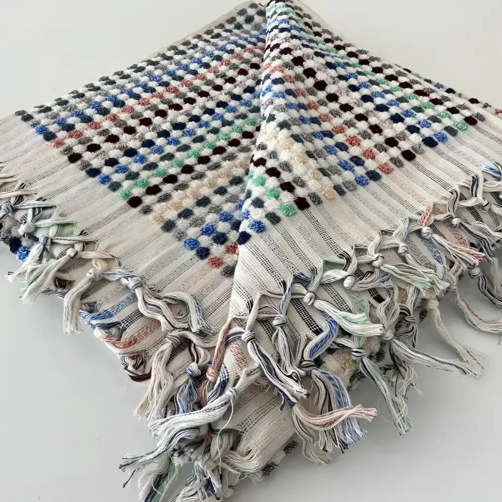 Handwoven Turkish terrycloth towel with dots in multiple colors and fringe.