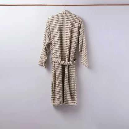 Beige and gray houndstooth patterned bathrobe with matching belt shown with dotted turkish terry hand loomed bath towel taupe