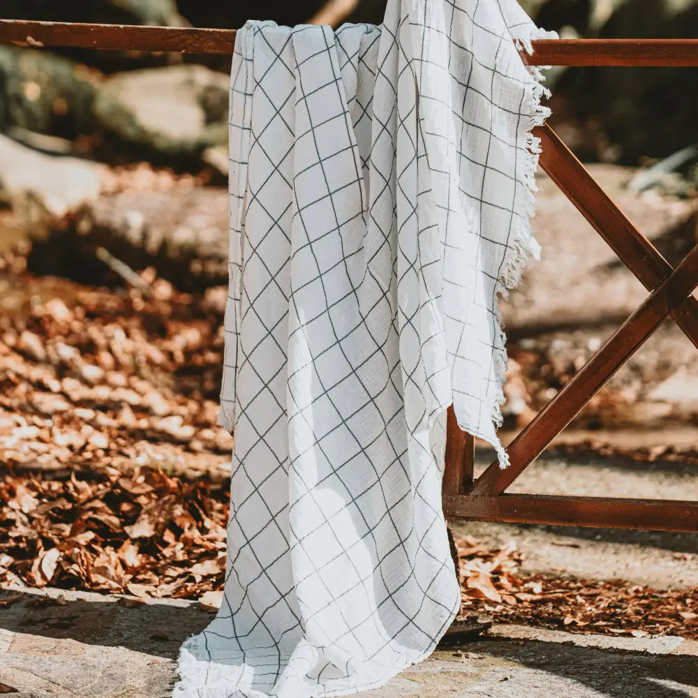 White with charcoal windowpane design 100% cotton muslin oversized throw blanket with fringe.