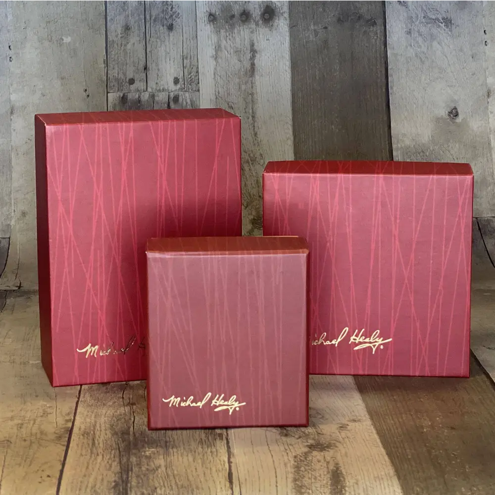 Three red boxes with a gold logo on a wooden surface