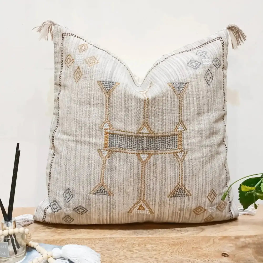 Cotton pillow cover in neutral gray color pallette with hand embroidered details.