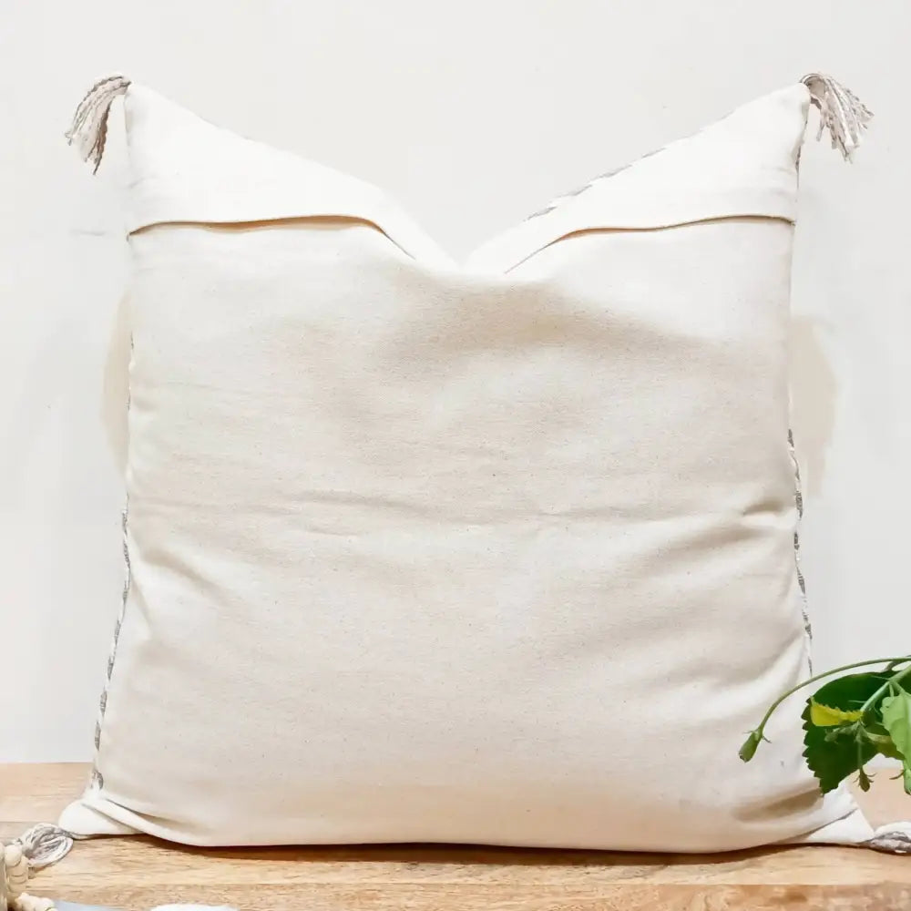 Cotton pillow cover in neutral gray color pallette with hand embroidered details.