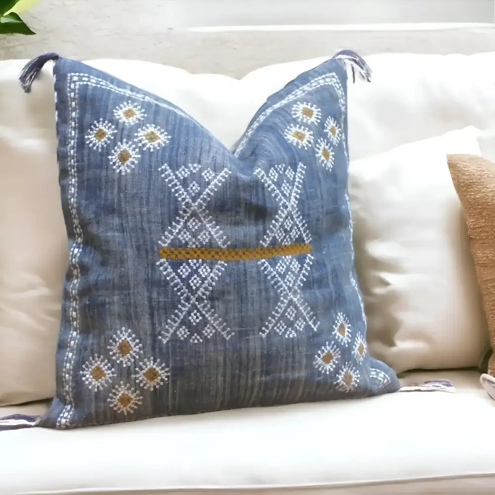Linen pillow cover 20 inch x 20 inch in blue, with hand embroidered details in white and brown. Tassels on corners and zipper on back side.
