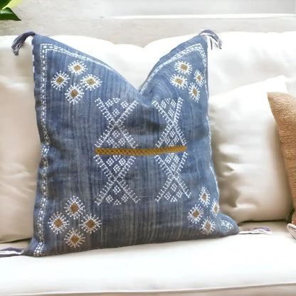 Linen pillow cover 20 inch x 20 inch in blue, with hand embroidered details in white and brown. Tassels on corners and zipper on back side.