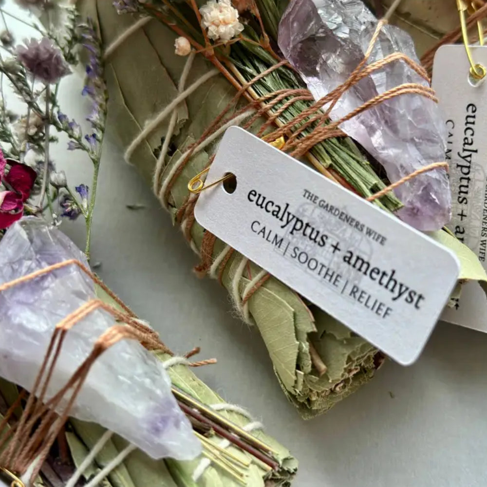 Handmade eucalyptus and amethyst wand with dried leaves, crystals, and twine