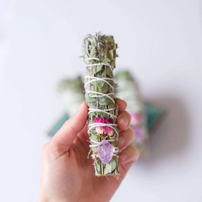 Hand wrapped smudge plants including sage, flowers, eucalyptus, and embellished with crystals.