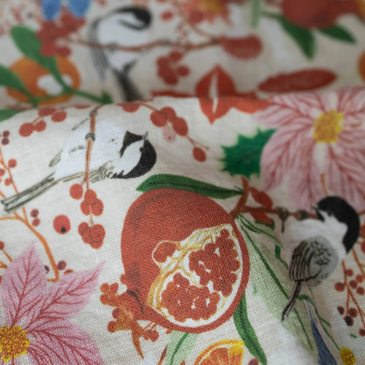 Vibrant pomegranate patterned linen tea towel with floral accents