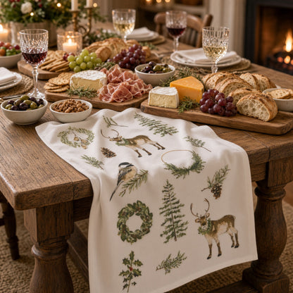 White linen cotton flour sack tea towel with embroidered woodland reindeer birds wreaths and pine branches in green and brown