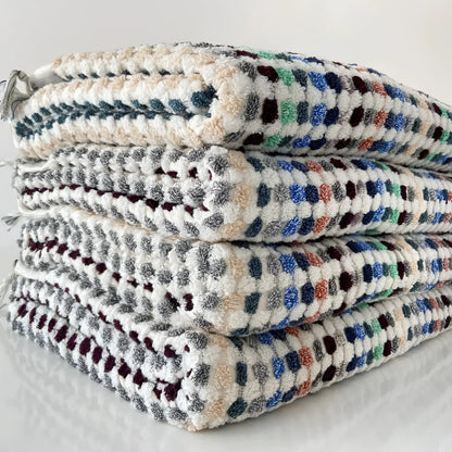 Stack of Flamingo Dotted Turkish Bath Towels with colorful square patterns and tasseled fringe