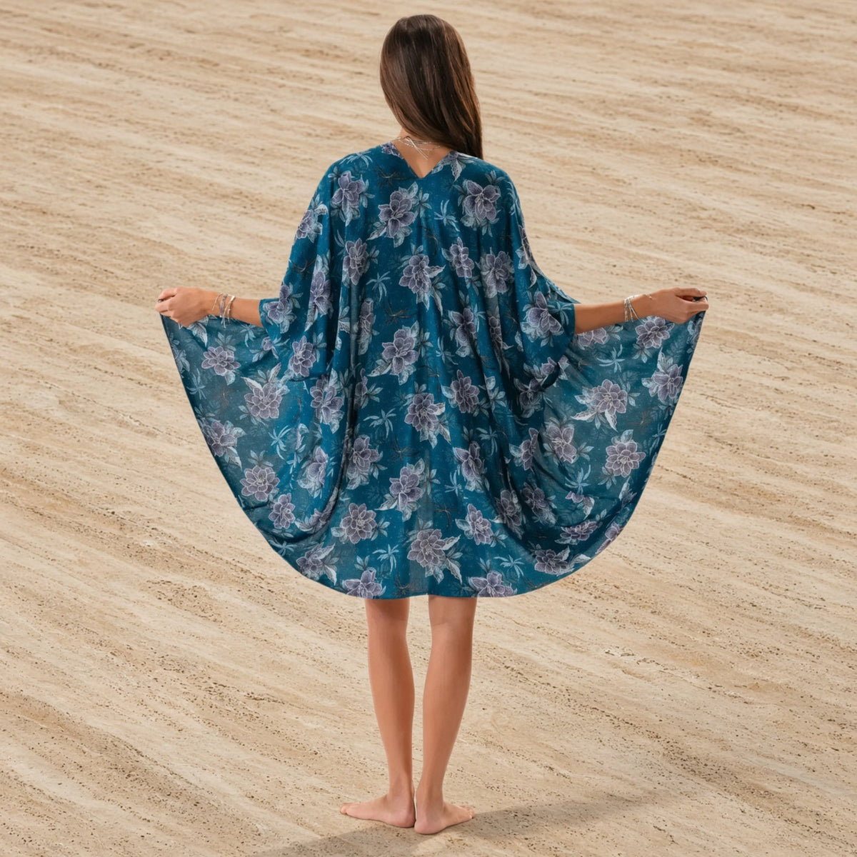 A flowing teal floral kimono cover made of lightweight fabric with a delicate purple floral pattern perfect for the beach